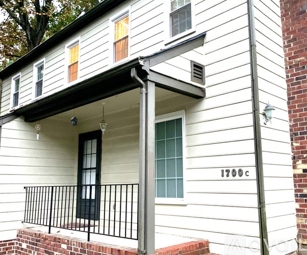 A white house with black railings and a black door.