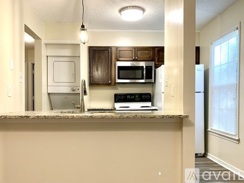 A kitchen with a white fridge, microwave, and oven.