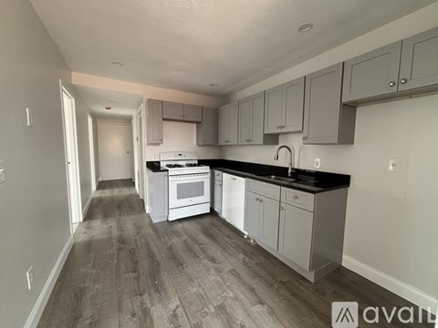 A kitchen with white appliances and grey cabinets.