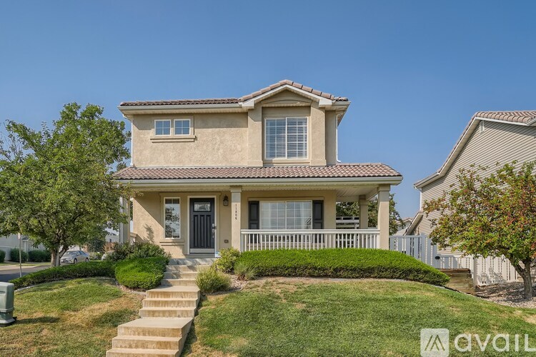 A house with a beige exterior and a black front door.