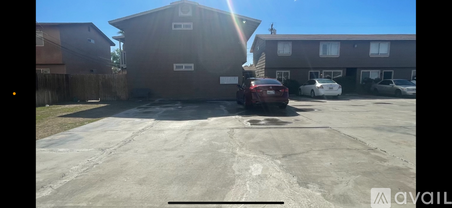 A parking lot with a building and cars.