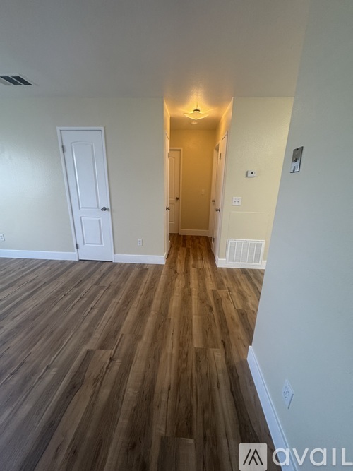 A hallway with wooden floors and two doors.