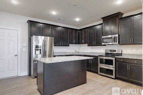 A kitchen with dark brown cabinets and stainless steel appliances.