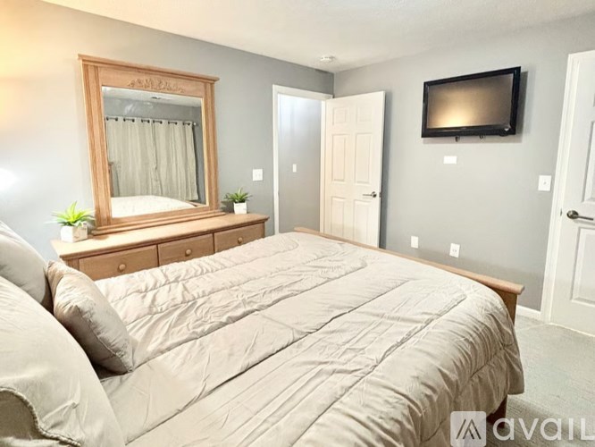 Three garage doors are closed on a brick building.