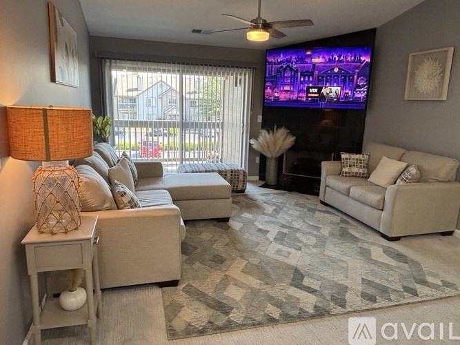 A well-lit living room with a dining area and a kitchen in the background.