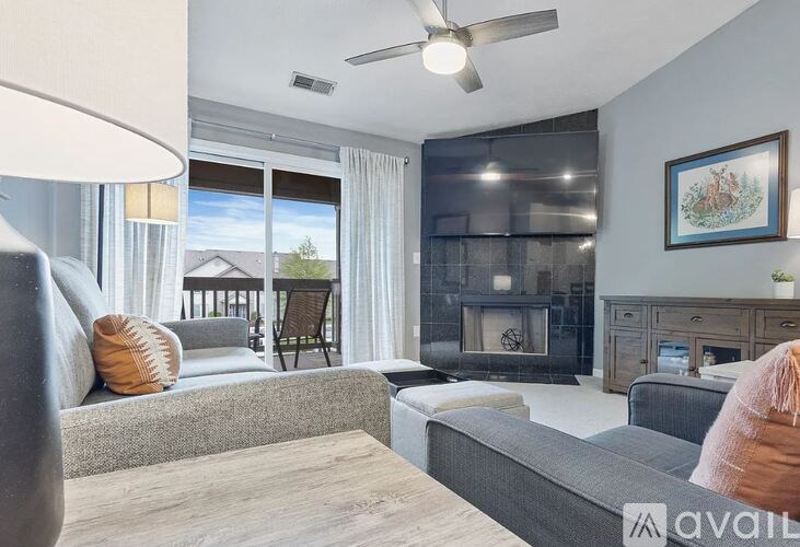 A modern living room with a grey sofa, a wooden coffee table, and a fireplace.