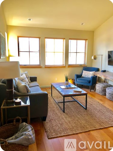 A living room with a grey couch, a blue chair, and a coffee table.