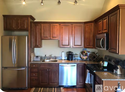 A kitchen with brown cabinets and a stainless steel refrigerator.