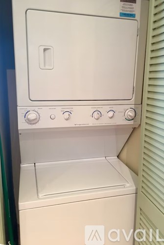 A white dryer is sitting in a small space.