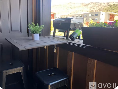 A small table with a potted plant on it sits on a balcony.