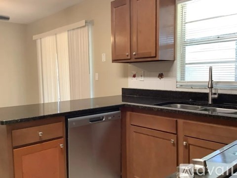 A kitchen with wooden cabinets and a black countertop.
