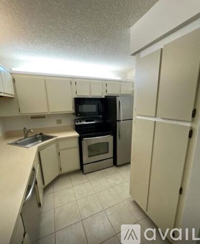 A kitchen with white cabinets and a black stove.