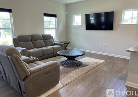 A living room with a grey sofa and a black table.
