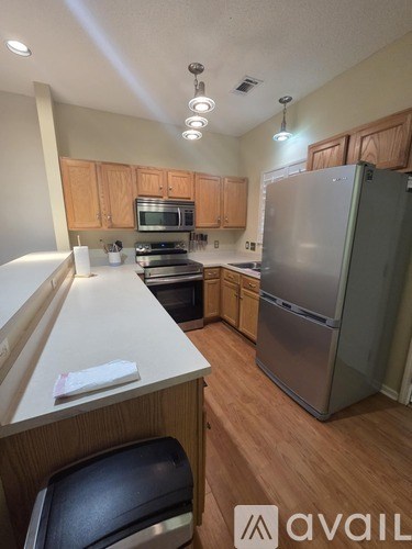 A kitchen with wooden cabinets and a refrigerator.