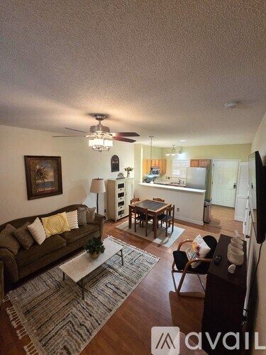 A living room with a couch, a coffee table, and a television.