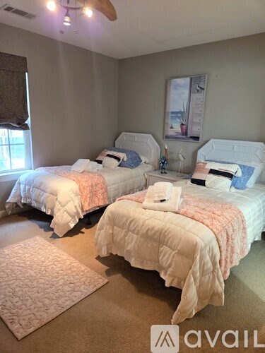Two twin beds with white bedding and pillows in a room.