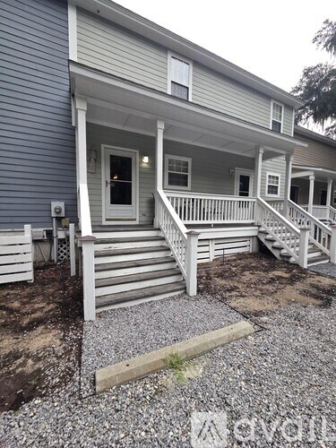A house with a front porch and stairs leading up to the door.