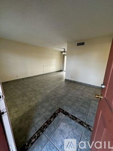 A room with a tiled floor and a red door.