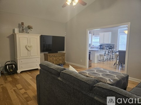 A living room with a grey couch and a white cabinet with a heart design on it.