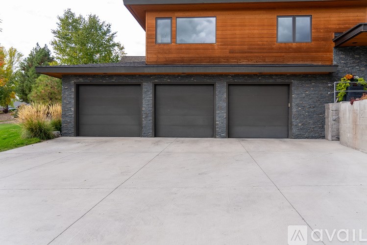 A modern house with a wooden facade and two garage doors.