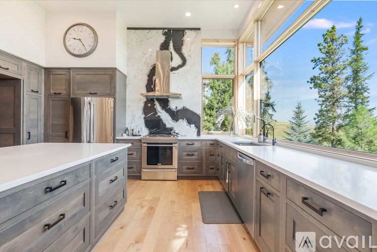 A modern kitchen with wooden cabinets and a marble backsplash.