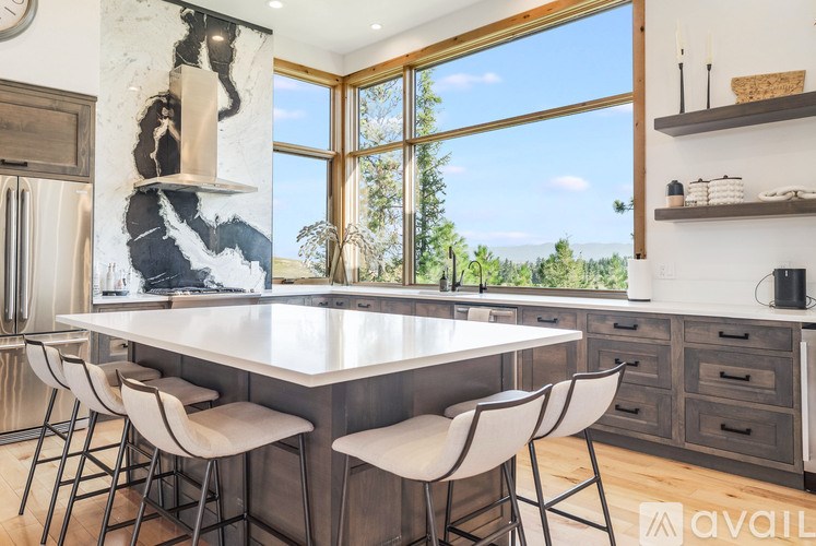 A modern kitchen with a large island and a view of the outdoors.