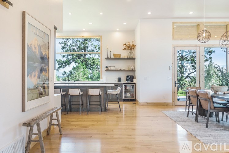 A modern dining room with a wooden floor and a large window.