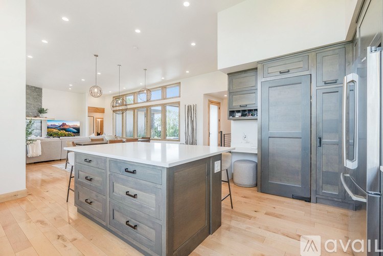 A kitchen with a large island and wooden floors.