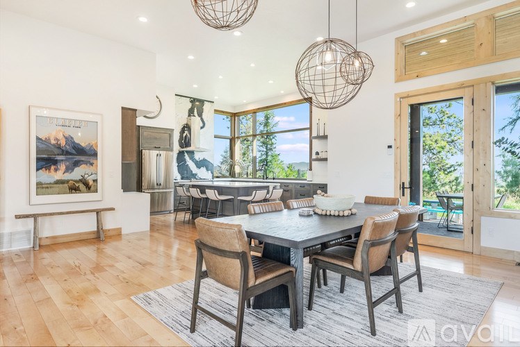 A dining room with a large table and chairs.