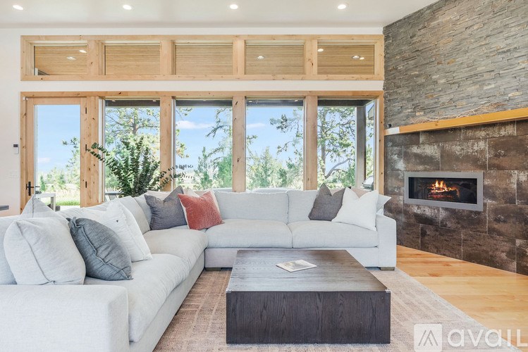 A modern living room with a fireplace and a large window.