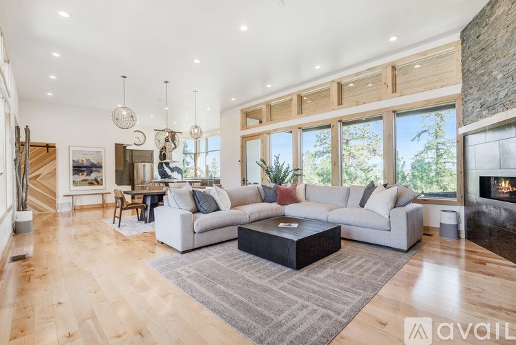 A spacious living room with a fireplace and a large window.
