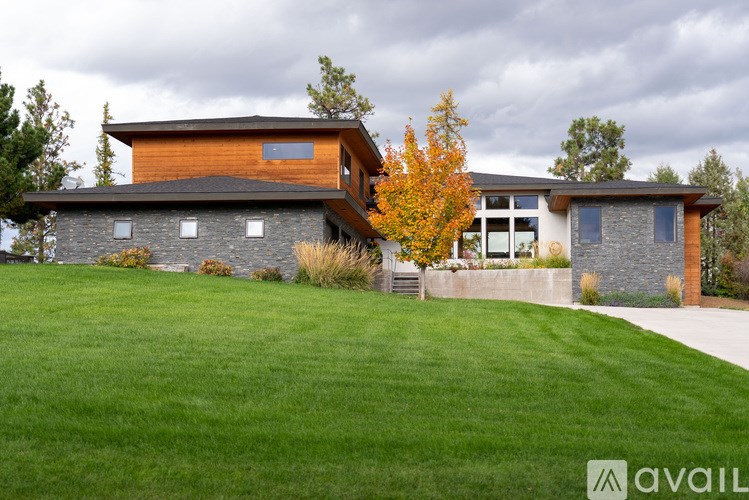 A modern house with a large front yard.