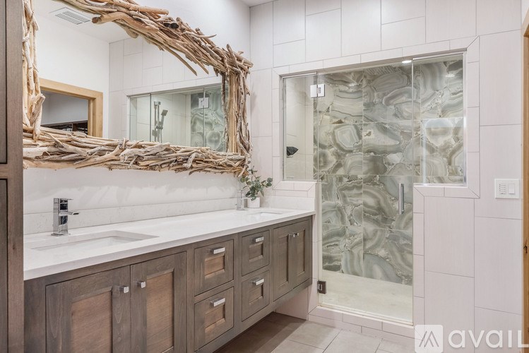 A bathroom with a wooden mirror frame and a walk-in shower.