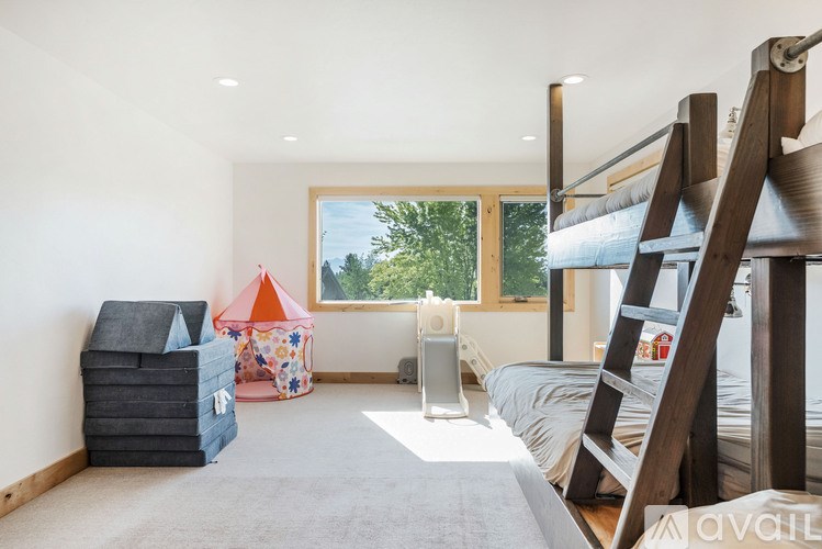 A room with a bunk bed, a play tent, and a speaker.