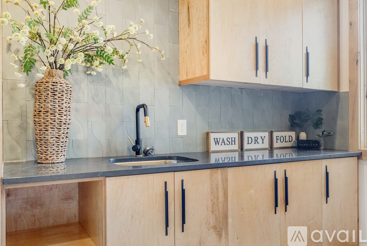 A kitchen with wooden cabinets and a sink with a black faucet.