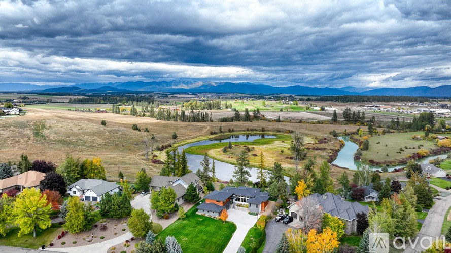 A suburban neighborhood with houses and a lake in the background.