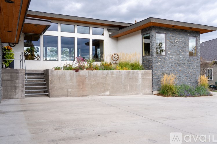 A modern house with a stone pillar and a wooden roof.