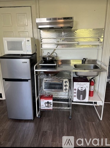A kitchen area with a refrigerator, microwave, and oven.