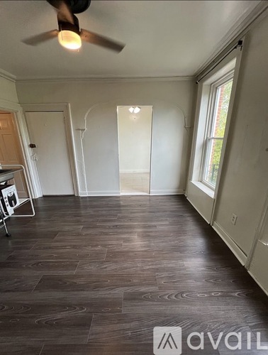 A room with a tiled floor and a window with bars.