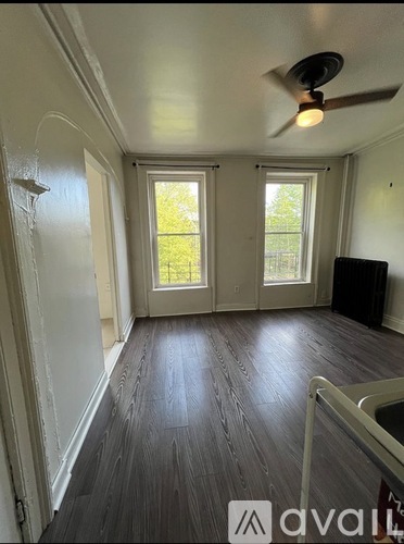 A room with a tiled floor and a window with bars on it.