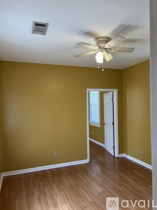 A room with a ceiling fan and a door.