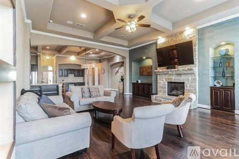 A living room with a grey couch and a fireplace.