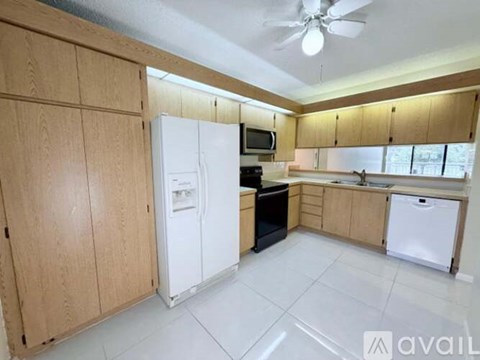 A kitchen with wooden cabinets and white appliances.