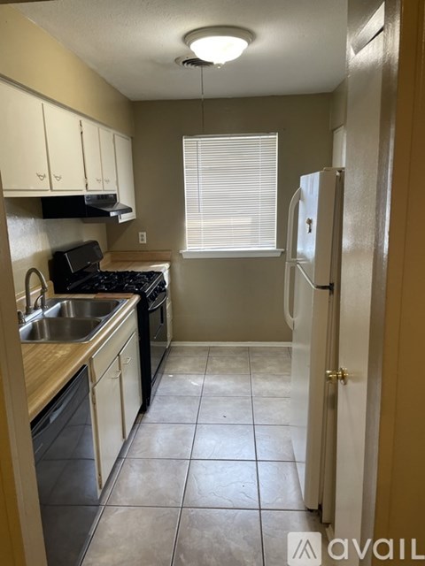 A kitchen with a refrigerator, sink, and stove.