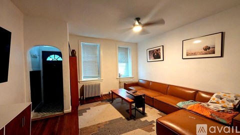A living room with a brown couch and a television.