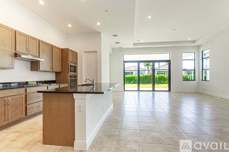 A kitchen with brown cabinets and black countertops.
