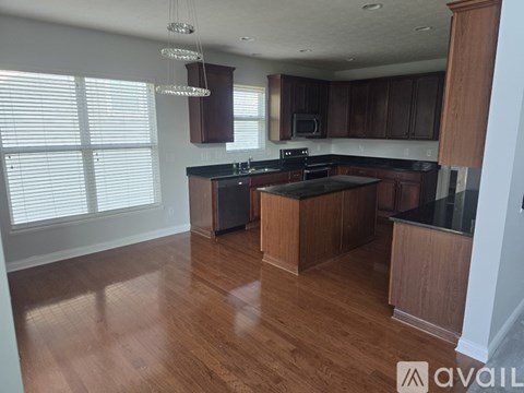 A kitchen with wooden cabinets and black countertops.