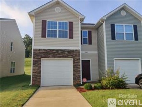 A two-story house with a garage is for sale.