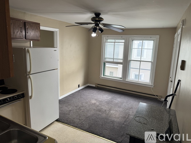 A room with a ceiling fan and two doors.