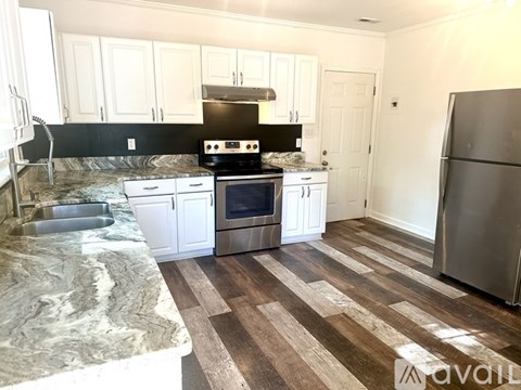 A kitchen with white cabinets and a marble countertop.